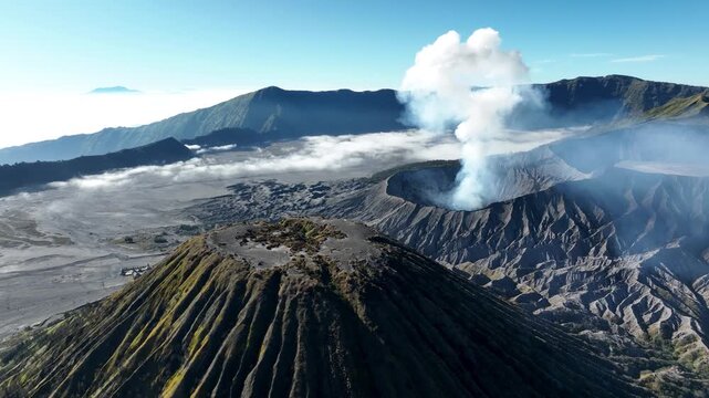 Closeup of Mount Batok With Smoke Rising From Mount Bromo Volcano In The Background In East Java, Indonesia. - aerial shot
