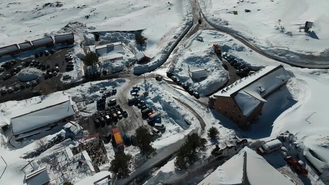 High aerial establishing shot of Mount Etna base camp in snowy winter landscape, 4K