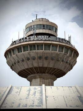 Close-up view of a circular observation tower featuring large letters 'ZVARTNOTS' on its exterior, with multiple windows and a cloudy sky in the background