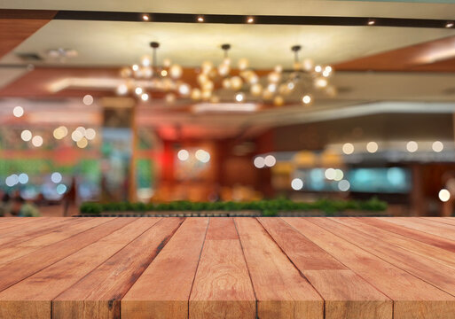 wooden table top with blurred restaurant lighting background