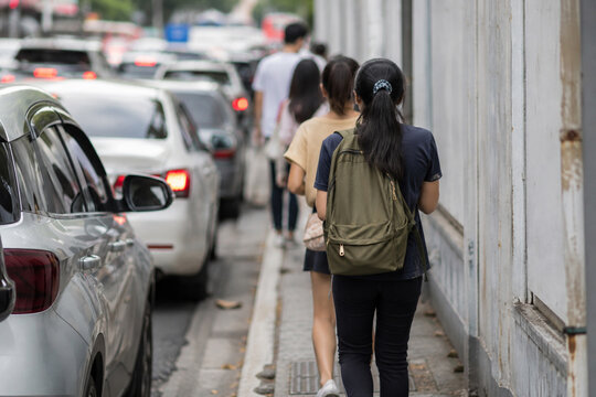 AI generated pedestrians navigating narrow sidewalk beside heavy urban traffic showing crowded city commuting limited walking space road safety daily mobility