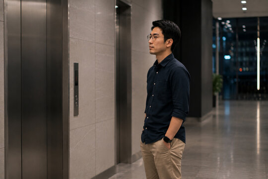 AI generated worker waiting alone for an elevator late the evening showing overtime solitude quiet workplace routine patience modern corporate life