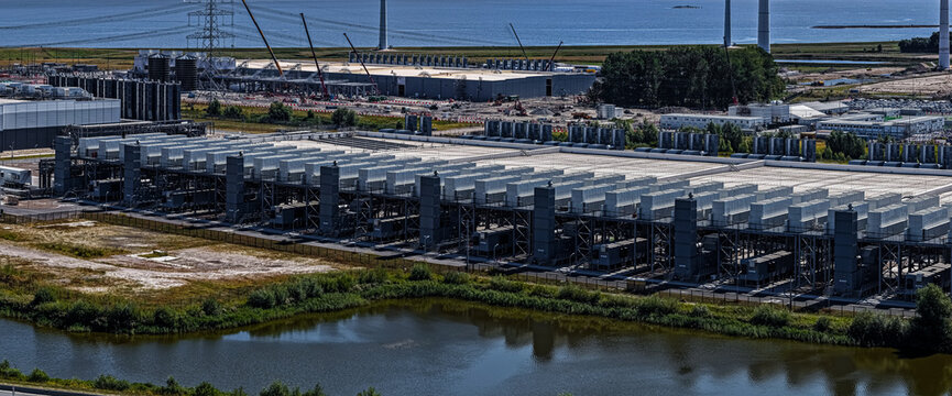 Eemshaven, Groningen, Netherlands - 13 August 2026: Aerial view of industrial facilities and data center infrastructure at Eemshaven, with cooling units and rooftops near the coast.
