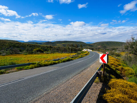 Scenic view of the R62 winding through the Little Karoo and crossing the Groot River near Ladismith in the Western Cape, South Africa, a spectacular route through rugged mountains and arid scenery.