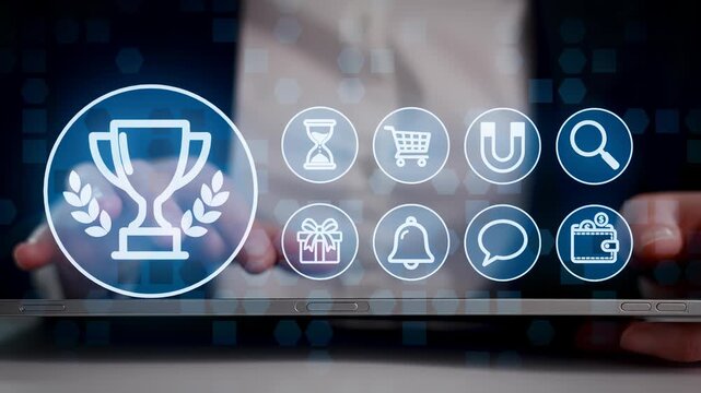 A person is interacting with a tablet that shows various digital icons. The main focus is on a trophy symbol, highlighting achievement. This occurs in a business environment.