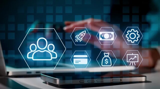 In an office, a person gestures with hands while digital icons appear on screens. The icons relate to business, finance, and technology. The atmosphere has a modern feel with focus on innovation.