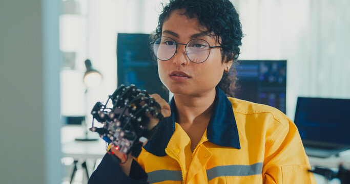 Close-up young Black female engineer coding AI robot arm in modern laboratory. Robotics, artificial intelligence, technology, stem, future, innovation, diversity, automation, machine learning concept.