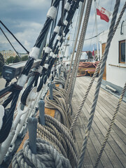 Details of ropes, rigging, and wooden deck on a historic sailing ship  © Marcin