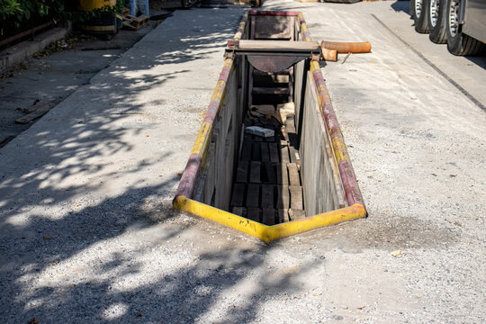 An outdoor inspection pit for vehicle maintenance and repair at a service station. Concept of automotive service, transport maintenance, and technical inspection facilities.