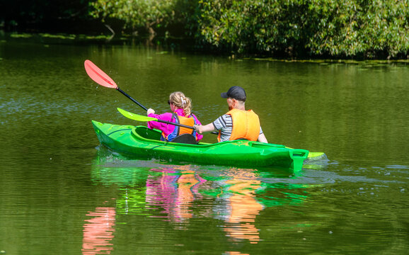 A man and a woman floating in a canoe on the river
