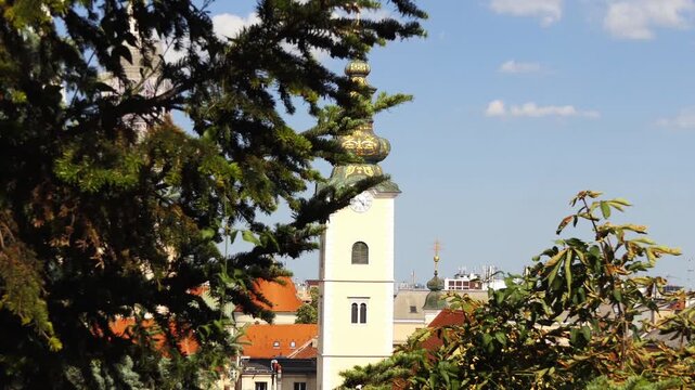 ZAGREB, CROATIA - JULY 12 2017: Church of St. Mary. Zagreb Cathedral of Assumption of Blessed Virgin Mary. Approach of camera. Fir tree in foreground. Panoramic View-Point of Zagreb City.