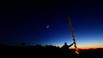 Silhouette of a person in nature observing night sky, Moon, stars and planets from a remote location. © astrosystem