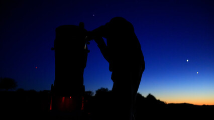 Amateur astronomer observing stars, planets, Moon and other celestial objects with a telescope in nature. © astrosystem