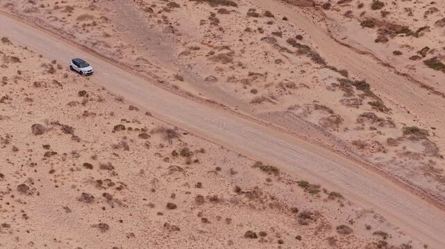 Aerial view of Sotavento beach in Jandia which is nine kilometer long virgin beach in Fuerteventura. Scenic Drone POV Exploration of Fuerteventura island. Cars on the dirt road in desert.             