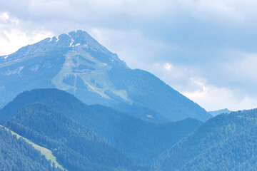 Fototapeta premium Bansko, Pirin, Bulgaria summer empty ski slopes and chairlift in green pine tree mountains