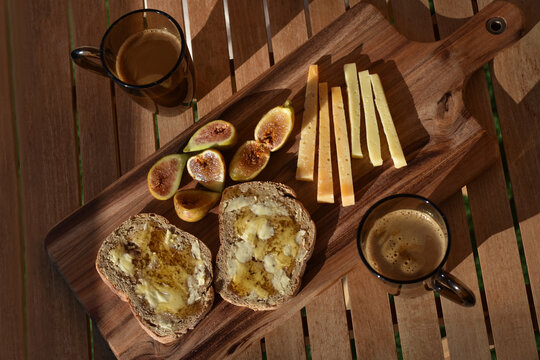 Rustic Mediterranean breakfast served outside on a wooden board