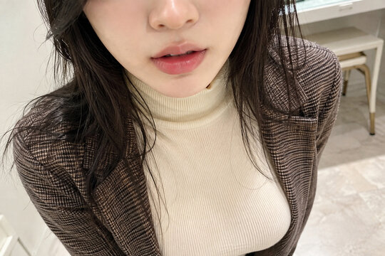 ブラウンのジャケットとクリーム色トップスの女性の近距離ポートレート