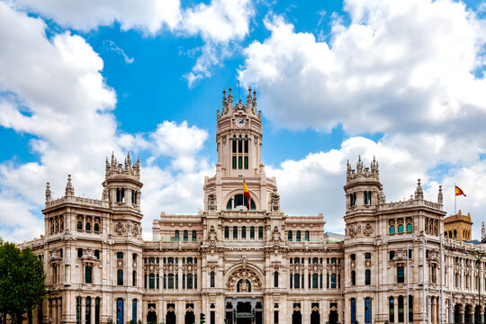 Palacio De Cibeles With Clock Tower And Spanish Flags