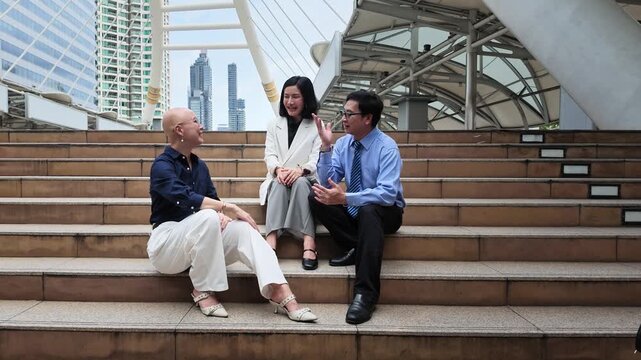 Two professionals having a discussion on contemporary urban steps with a vibrant city skyline in the background