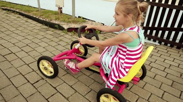Beautiful little girl rides mechanical go-kart