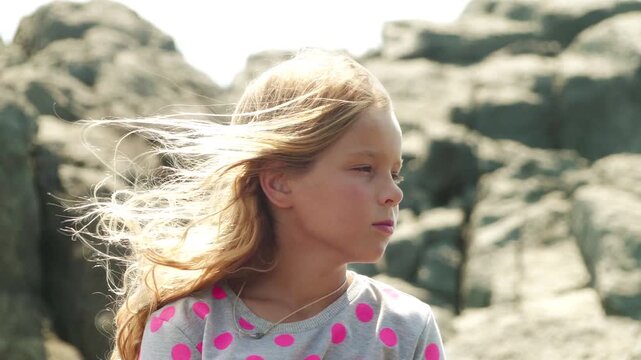 Little blonde girl with developing hair in wind