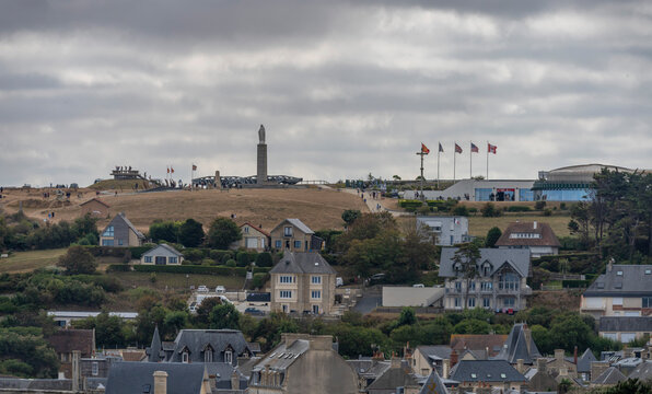 Arromanches-les-Bains, France - 08 10 2026: Panoramic view of the Statue of the Virgin Mary, panoramic cinema, The Garden of Remembrance, city and cloudy sky