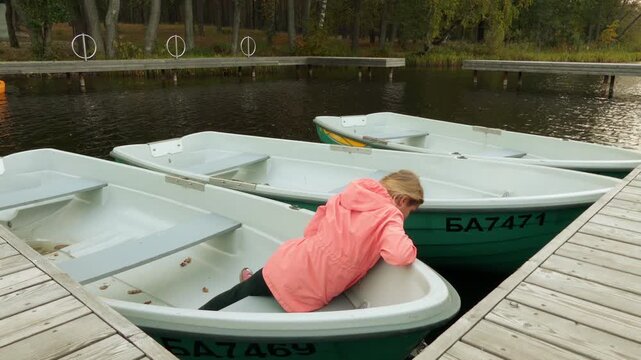 Little girl in a pink jacket sits on a boat