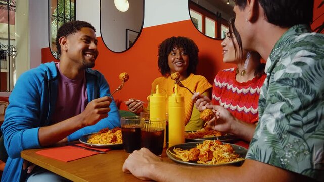 Multiethnic group of friends having meal at 80s vintage diner restaurant - Multiracial young people bonding and having fun, eating in an american fast food burger house