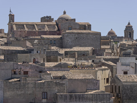 Telephoto view of the medieval townscape in Erice, Sicily, featuring the Chiesa di San Martino dome and bell gable dominating the skyline.