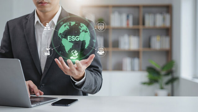 Businessman ESG sustainability globe technology office laptop corporate environment governance concept with holographic earth and icon overlay, professional holding digital interface