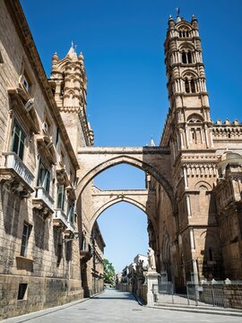 The iconic flying arches bridging the Archbishop's Palace to the western towers of Palermo Cathedral above Via Matteo Bonello in Sicily.