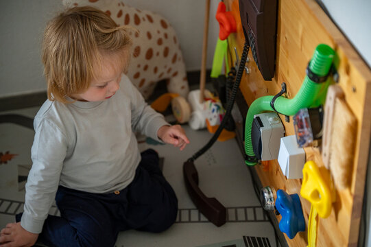 Toddler Exploring a Sensory Board with Real-Life Objects &ndash; Montessori-Inspired Learning, Fine Motor Skills and Child Development