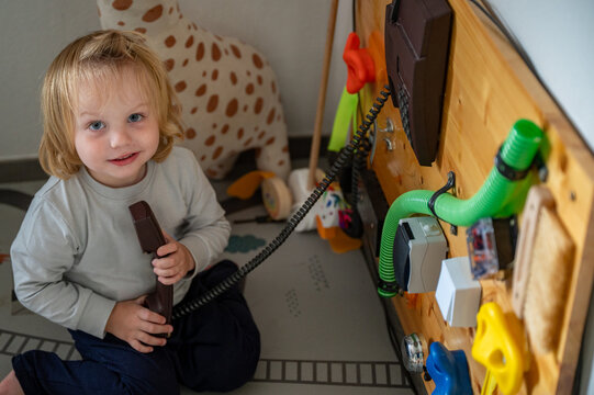 Toddler Exploring a Sensory Board with Real-Life Objects &ndash; Montessori-Inspired Learning, Fine Motor Skills and Child Development