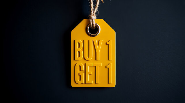 Bright yellow retail tag with BUY1GET1 text and metal eyelet hanging from twine against