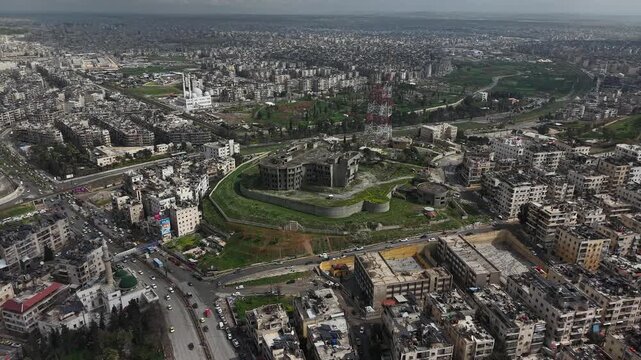 Drone view of a city landscape in Aleppo, Syria. Urban skyline and residential neighborhoods from above. City streets, infrastructure, and middle eastern architecture.