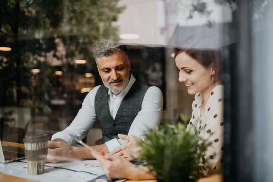 Woman showing project to client during business meeting in a coffee shop.