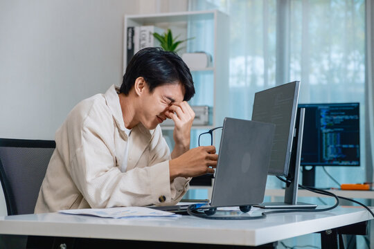 Tired programmer suffering stress and burnout while working at office on software development task