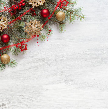 Christmas and New Year background with holiday decorations.  Fresh fir branches with Сhristmas ornaments on old white wooden shabby background with empty space for text. Flat lay.