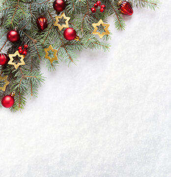  Fresh fir branches with Сhristmas ornaments on the background of natural snow with empty space for text. Christmas and New Year background with holiday decorations.  Flat lay.