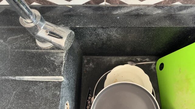Kitchen sink and chrome faucet covered with heavy limescale and hard water stains, dirty dishes, household cleaning problem, kitchen maintenance.