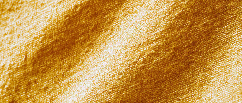 golden linen fabric texture macro closeup warm amber woven cloth background for sustainable wellness branding web design advertising packaging editorial natural organic backdrop
