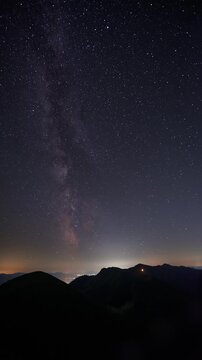 Vertical Milky Way Galaxy Timelapse Over Dark Mountain Landscape