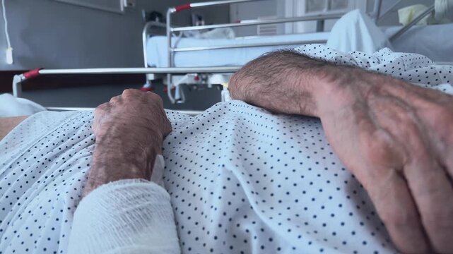 Close-up of a patient resting in a hospital bed. Anonymous older man, no faces.