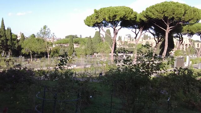 Rome Italy Imperial Forum panorama, scenic aerial view from the Rose Garden on Aventine Hill over ancient Roman ruins and Palatine Hill, sunny travel and historical 4K video footage.