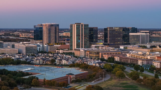Plano, Texas, United States - 16 November 2025: Aerial view of the Plano skyline at dusk, featuring modern office buildings, residential complexes, and surrounding greenery.