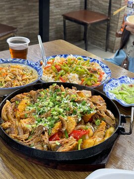 Hot iron pot dish with scallions and sesame served with noodles, Chinese restaurant