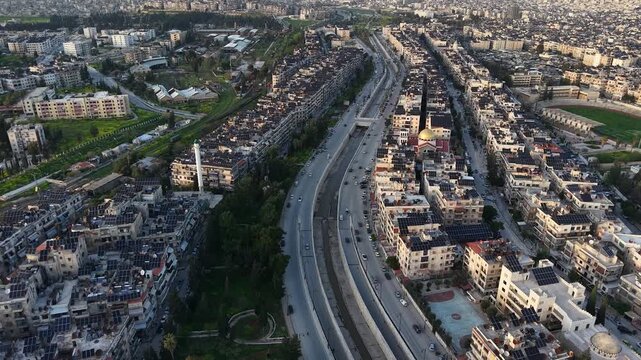 Drone view of a city landscape in Aleppo, Syria. Urban skyline and residential neighborhoods from above. City streets, infrastructure, and middle eastern architecture.