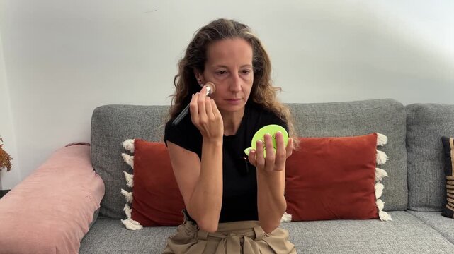 Mujer aplic&aacute;ndose polvos de maquillaje antes de grabar
