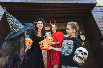 Fototapeta premium Family enjoying Halloween with costumes and treats in a cozy home
