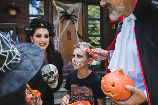 Festive family fun in Halloween costumes celebrating near a cozy cottage